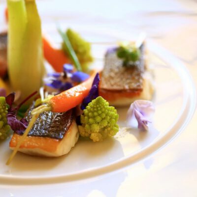 Plat gastronomique raffiné, poisson grillé et légumes frais, idéal pour améliorer rentabilité hôtel grâce à une présentation élégante et une cuisine de haute qualité, attirant une clientèle exigeante.