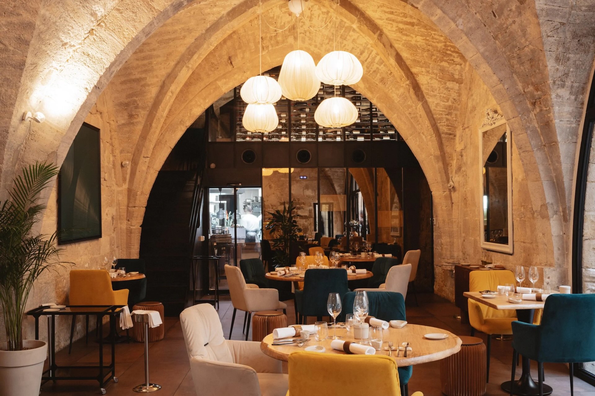 Restaurant élégant d’un hôtel, décor raffiné et voûtes en pierre, idéal pour audit hôtel, ambiance sophistiquée, tables préparées pour une expérience gastronomique de qualité.