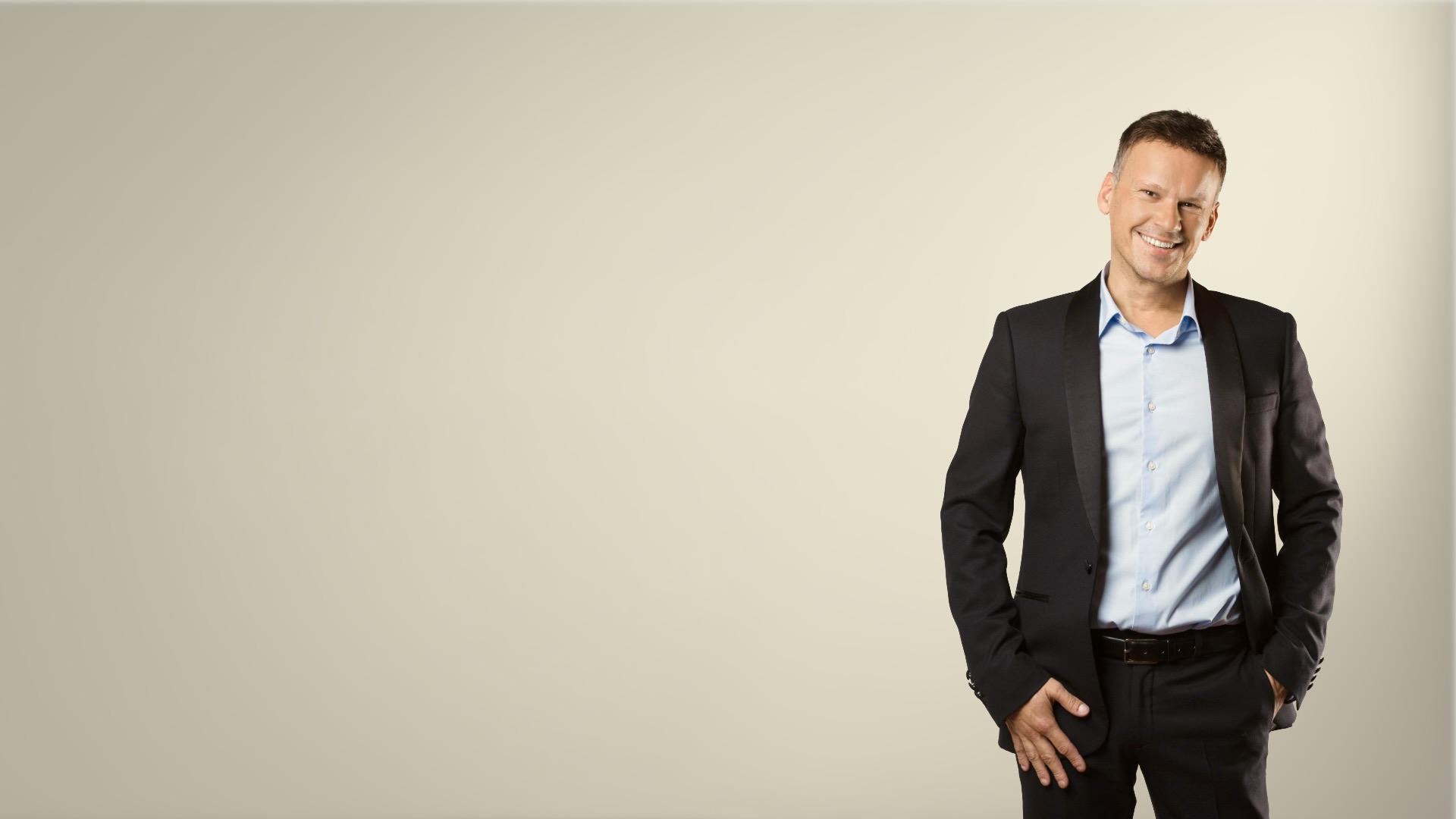 Homme en costume élégant représentant Ludovic Henry, expert hôtellerie Bpifrance, debout devant un fond neutre, posture professionnelle et confiante.