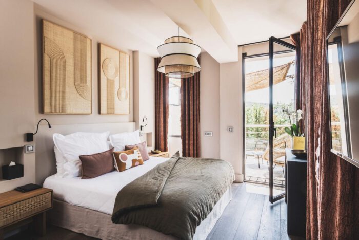 Chambre d’hôtel moderne et élégante, avec vue sur balcon, idéale pour améliorer rentabilité hôtel grâce à un espace confortable et bien décoré, invitant à la détente.