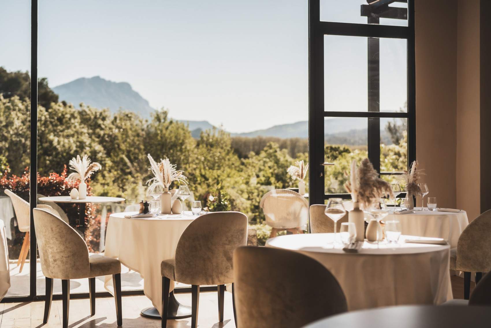 Vue élégante d’un restaurant moderne, baigné de lumière naturelle, illustrant l’excellence du conseil opérationnel hôtellerie avec une décoration raffinée et une vue panoramique sur la nature.