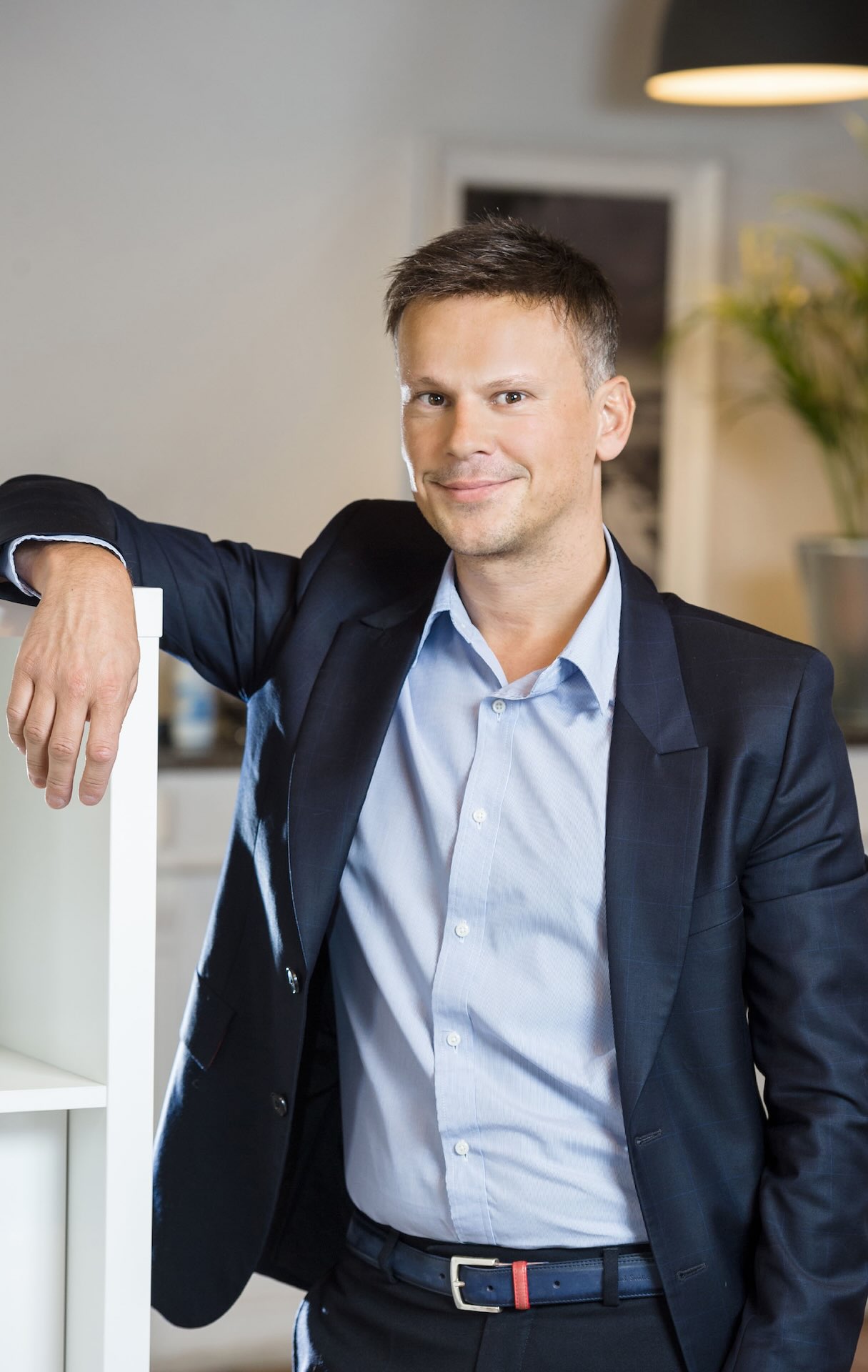 Consultant hôtellerie professionnel en costume posant dans un environnement moderne, symbolisant le service de conseil et l’expertise dans le secteur hôtelier.