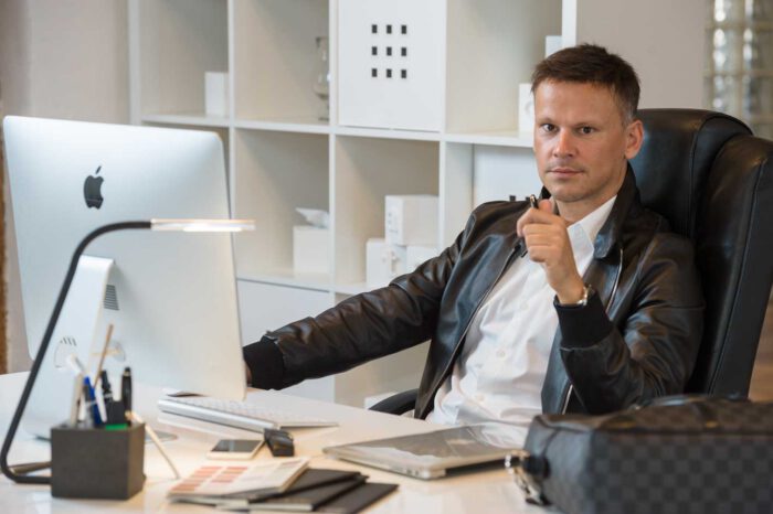 Ludovic Henry, expert hôtellerie Bpifrance, assis à un bureau moderne avec ordinateur et accessoires professionnels, montrant un environnement de travail élégant et organisé.